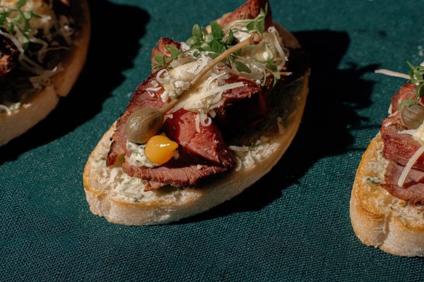 Brusketa su žolelių sviestu, rūkytu jautienos roastbeefu ir kaparais ir lašeline paprika